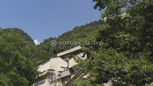 Drone aerial video footage of Okutama Industry Hikawa factory standing in the mountains of Okutama [Tokyo / Okutama Town, Japan]