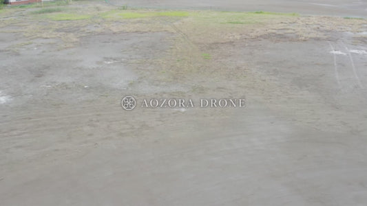 芝生と土のある校庭(グラウンド)の上空を飛行する映像 ドローン動画素材